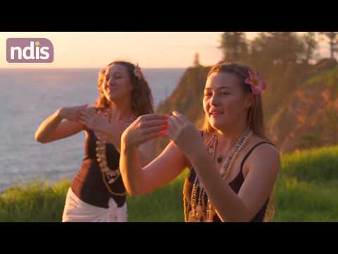 Two young women standing on an islands edge with flower necklaces