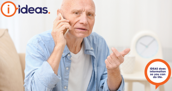 A senior man in a blue shirt is on the telephone. 