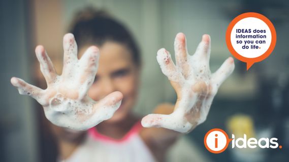 girl holding her soapy hands up