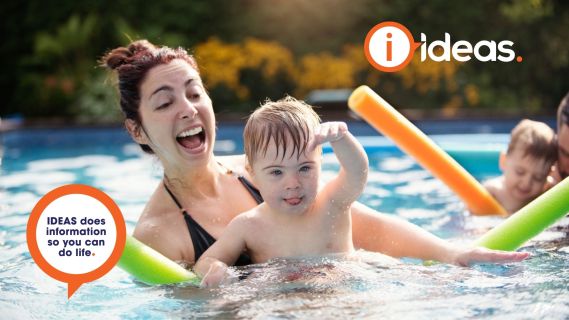 woman and small child playing in a swimming pool