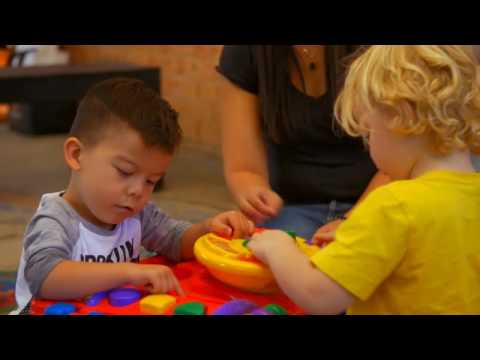 Two kids playing with toys on the floor