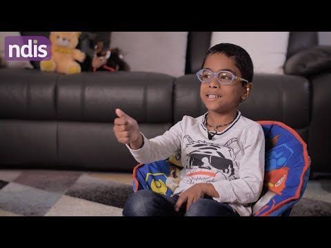 Boy sitting in chair in lounge room talking