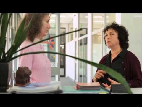 2 women standing in an office talking